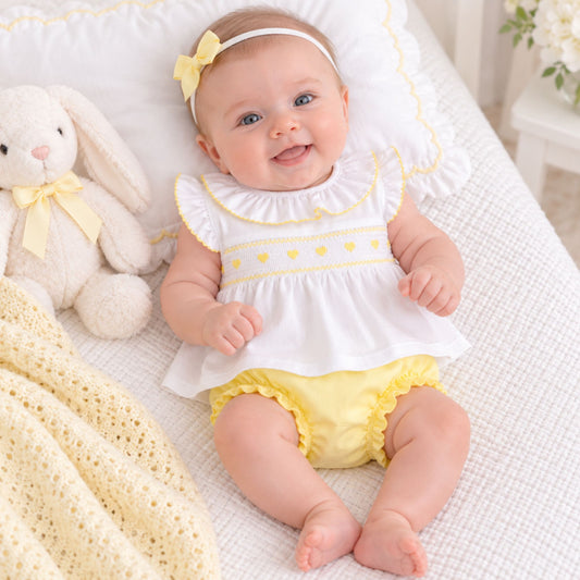 baby girl in lemon and white two piece with smocking heart design