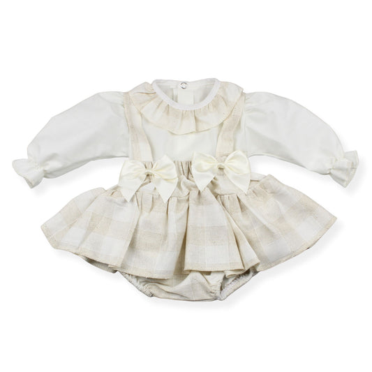 White baby dress with ruffled details and a bow on a white background