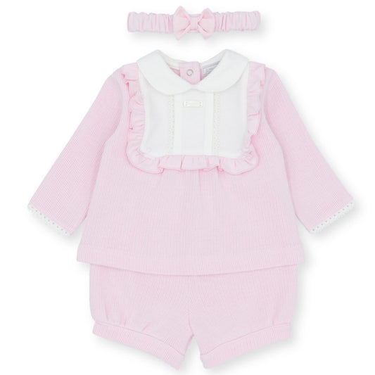 Pink baby outfit with ruffled details and matching headband on a white background