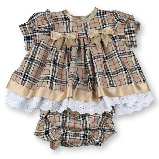 Plaid baby dress with ruffles and bow on a white background