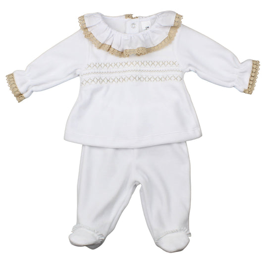 White baby outfit with ruffled collar and gold trim on a white background