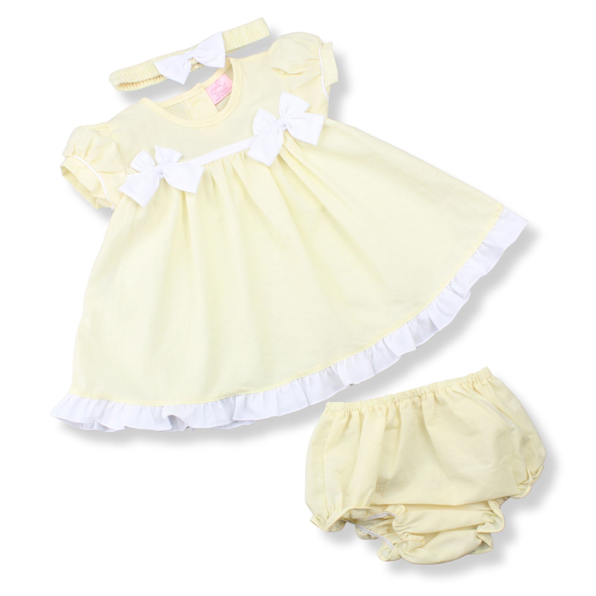 Yellow baby dress with white trim and matching bloomers on a white background
