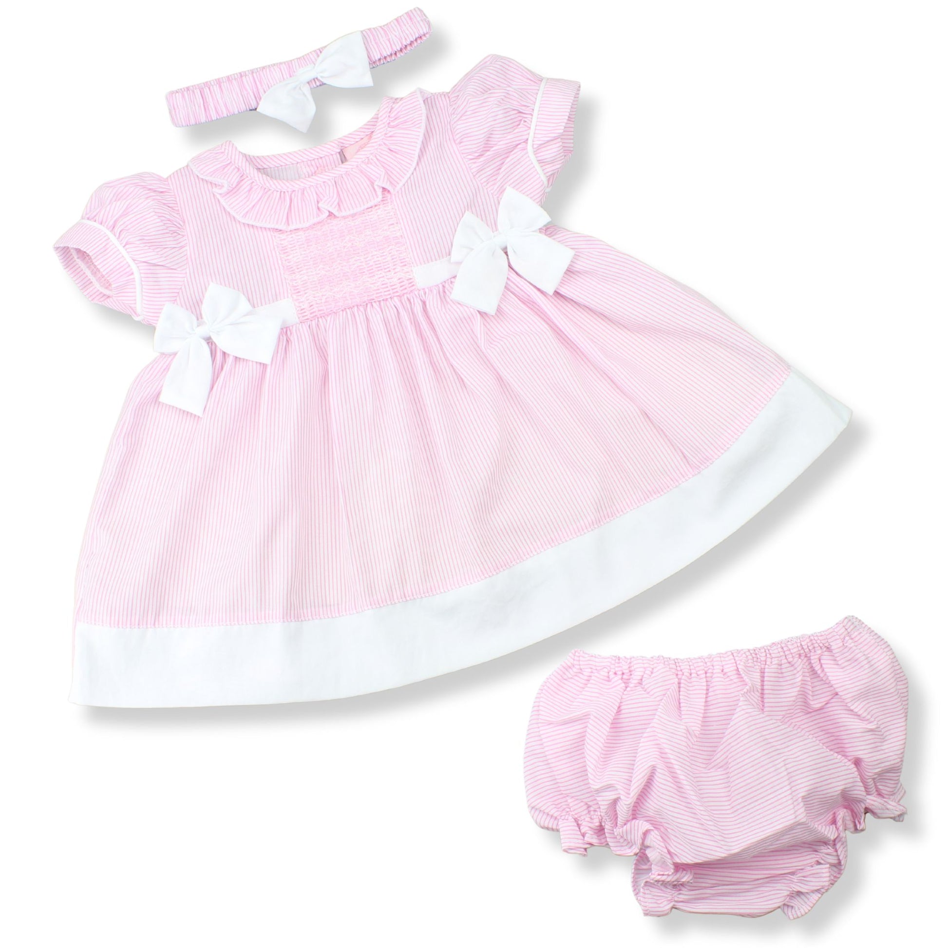 Pink baby dress with white trim and matching bloomers on a white background
