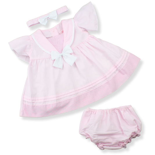 Pink baby dress with ruffles, bow, headband, and bloomers on a white background