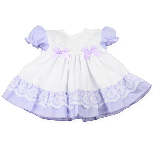 White dress with purple lace and bows on a white background