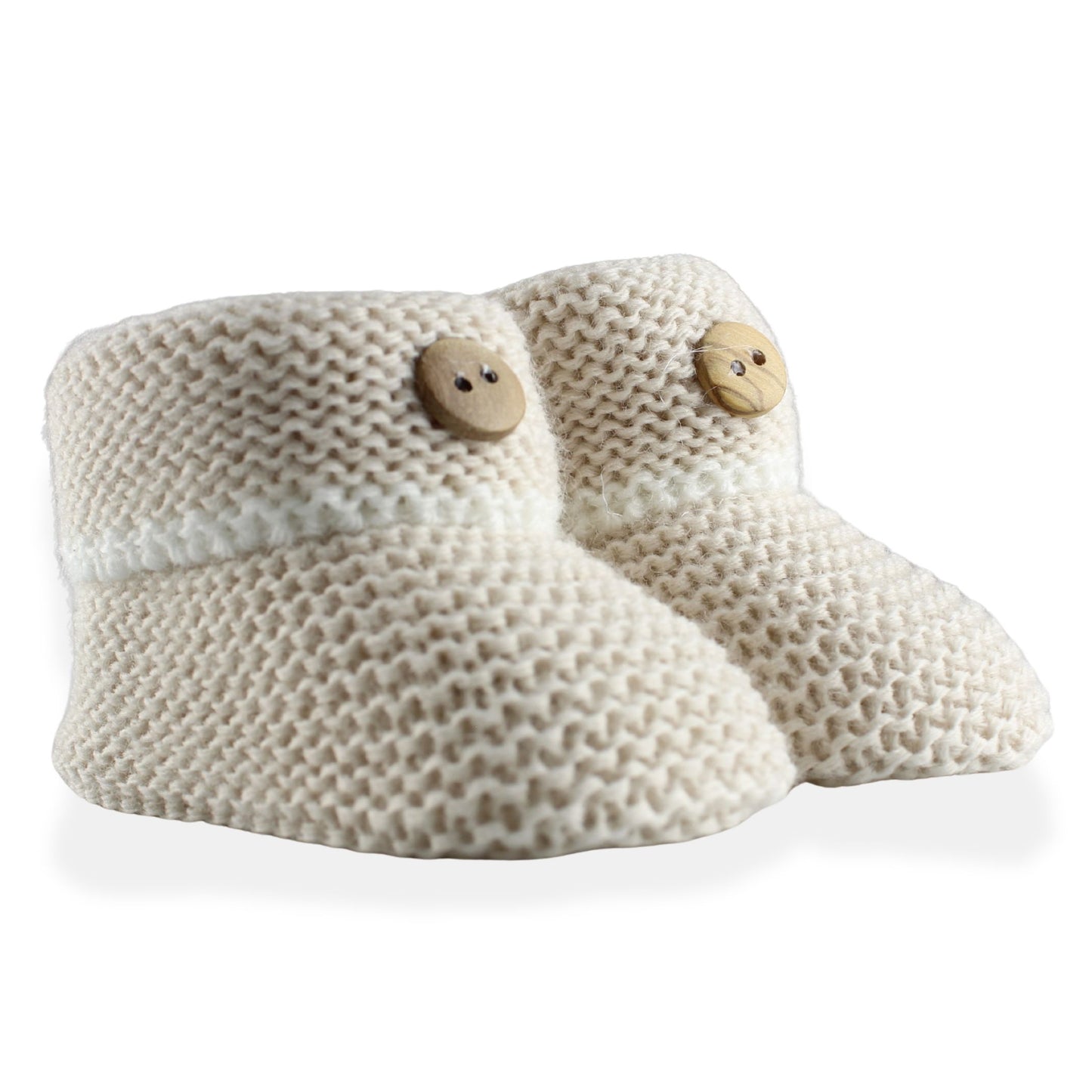 Pair of beige knitted baby booties with wooden buttons on a white background