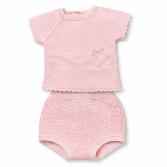 Pink baby outfit with top and knickers on a white background