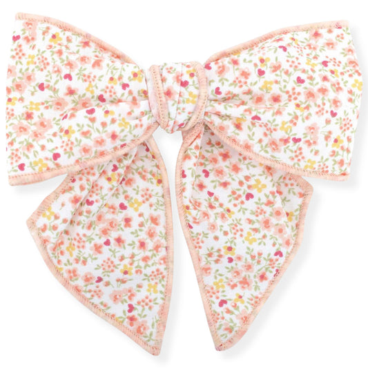 Floral patterned bow with pink accents on a white background