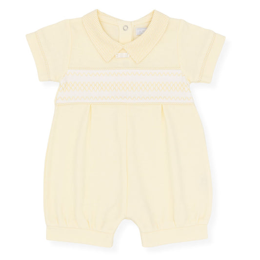 Yellow baby romper with white trim on a white background