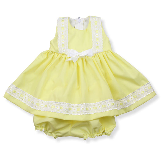 Yellow baby dress with white lace details on a white background