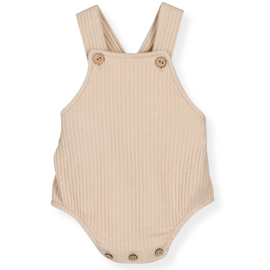 Beige romper with button details on a white background