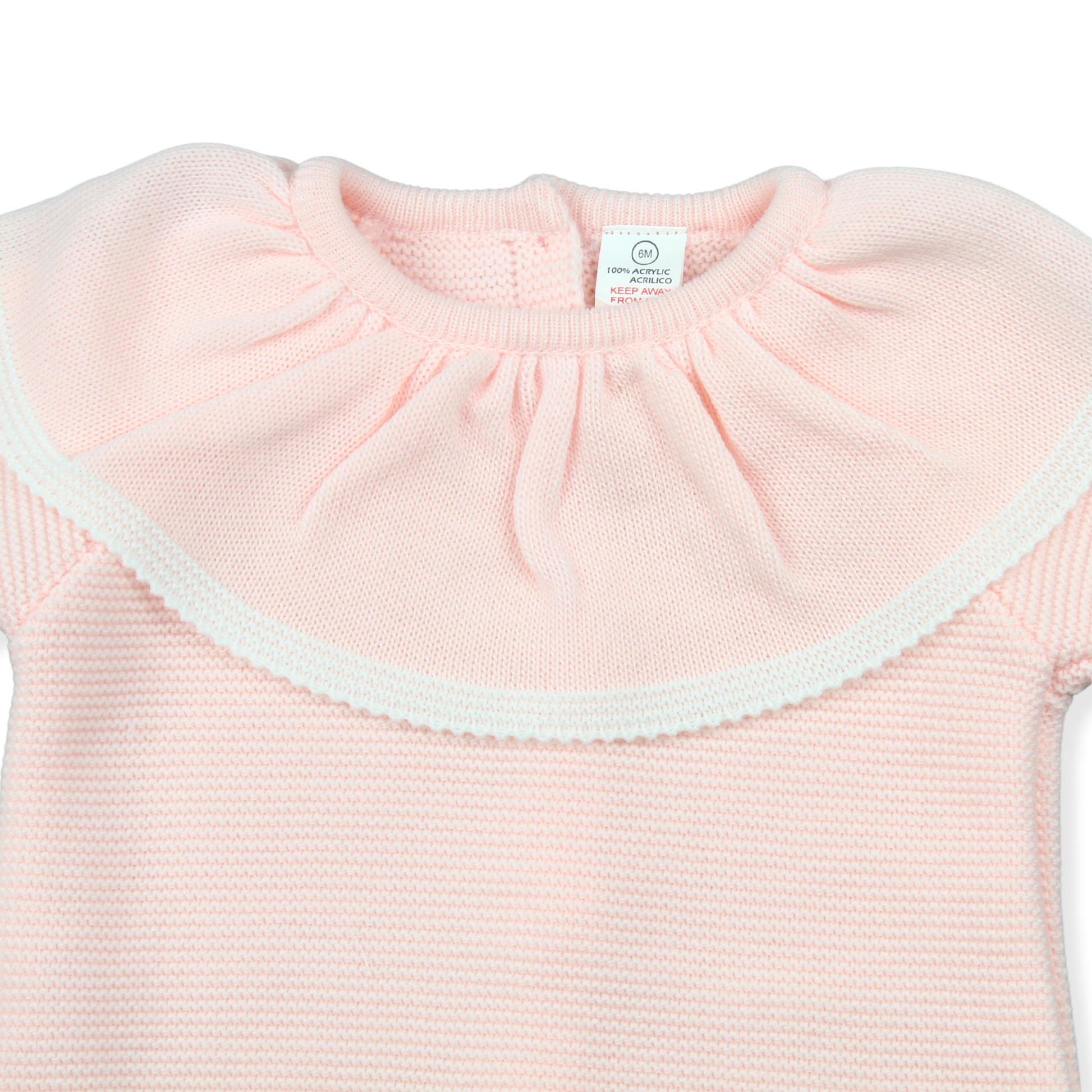 Close-up of a pink baby outfit with a white label on a white background