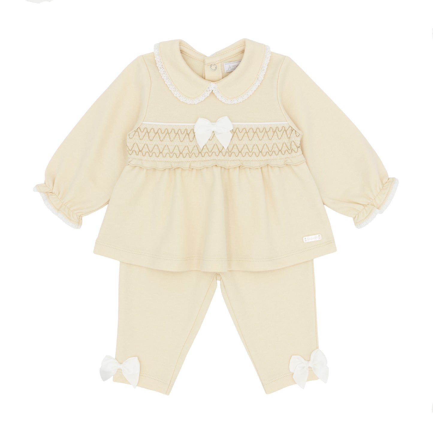 A baby girl's two-piece knit outfit set in beige, featuring a long-sleeve smocked top with a Peter Pan collar and matching pants with bow details.