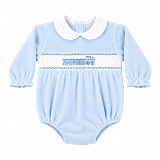 A baby long-sleeve bodysuit in light blue with a white Peter Pan collar, featuring a smocked horizontal stripe across the chest with a blue train motif.