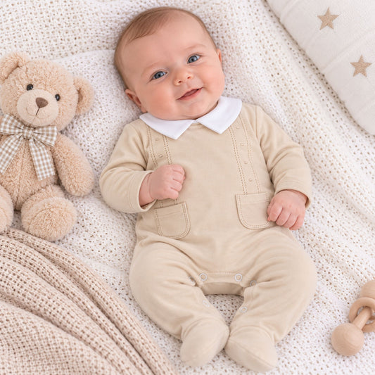 baby boy in beige cotton sleepsuit
