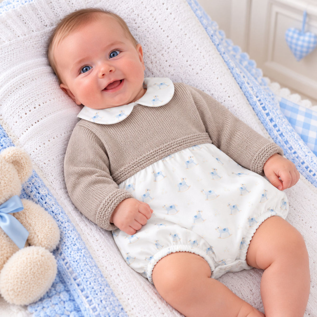 Baby boys beige knitted romper with blue rocking horse print and Peter Pan collar