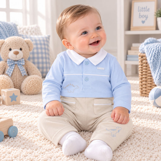 A baby sitting on a cream carpet in a bright nursery, wearing a light blue long-sleeve polo shirt with a white collar and beige pants with white socks.