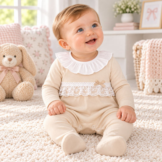 baby grl in beige sleepsuit with frill collar and lace