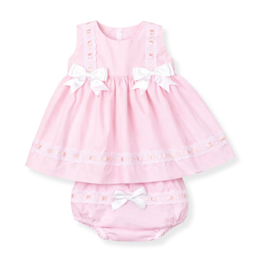 Pink baby dress with white bows on a white background