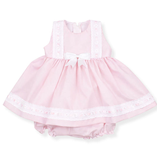 Pink baby dress with lace details on a white background