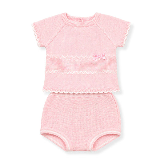 Pink baby outfit with top and knickers on a white