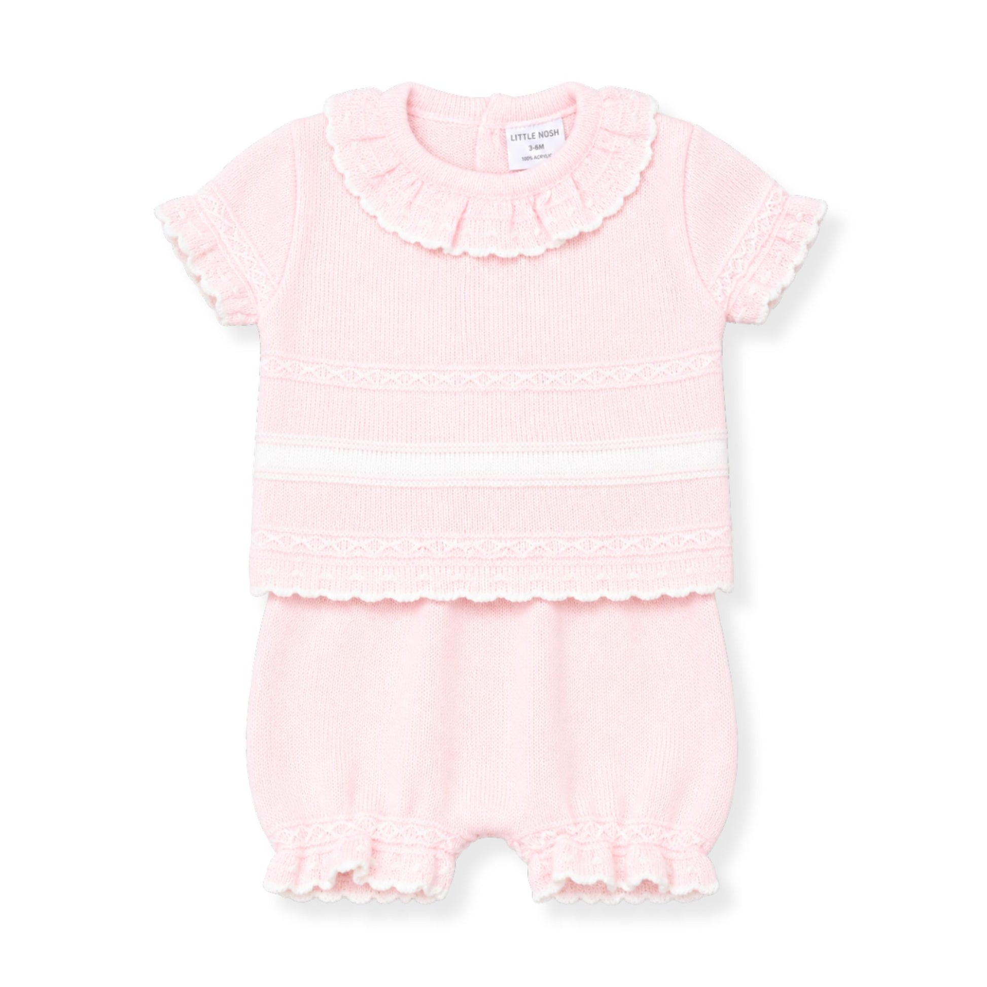 Pink baby outfit with ruffled details on a white background