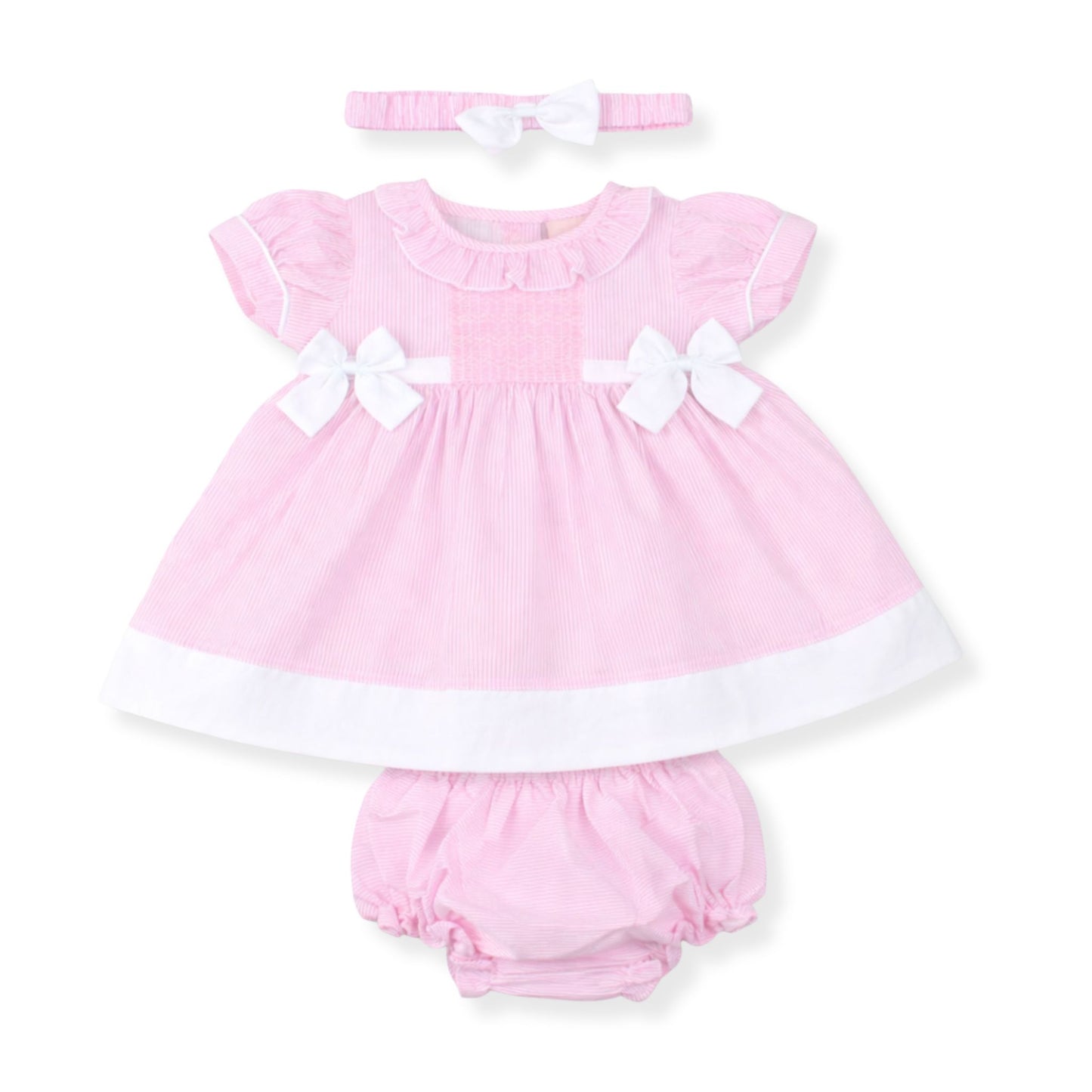 Pink baby dress with white bows, bloomers, and headband on a white background