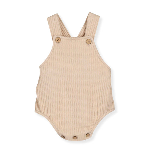 Beige romper with button details on a white background