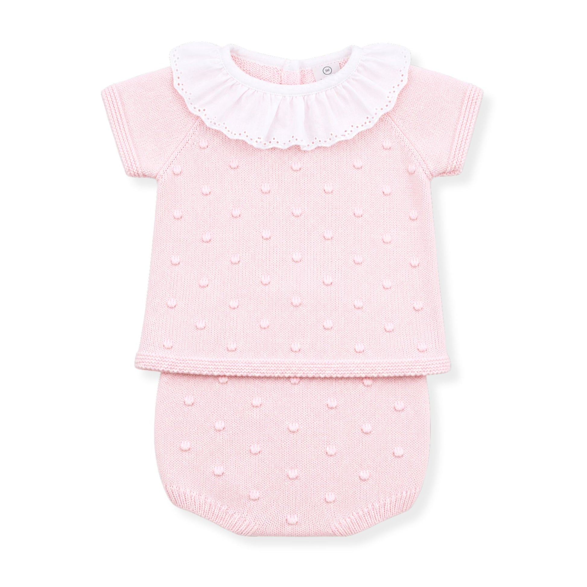 Pink baby outfit with ruffled collar on a white background