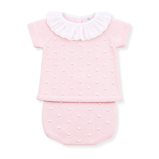 Pink baby outfit with ruffled collar on a white background