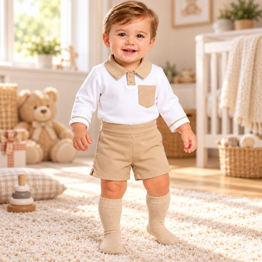 Baby boy wearing beige shorts and white long sleeve polo top two piece outfit