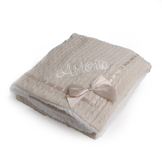 Beige personalised baby blanket with a bow and name  on a white background