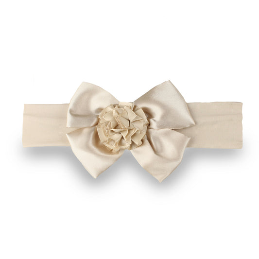A cream-colored fabric headband featuring a large satin bow and a matching fabric flower embellishment in the center, presented on a clean white background.