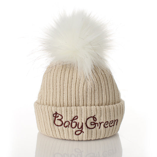 Beige knit beanie with white pom-pom and embroidered name 'Cillian' on a white background