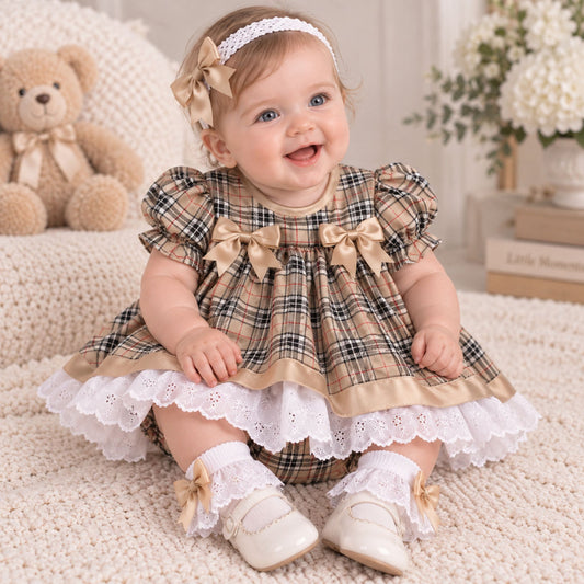 baby girl in beige tartan outfit