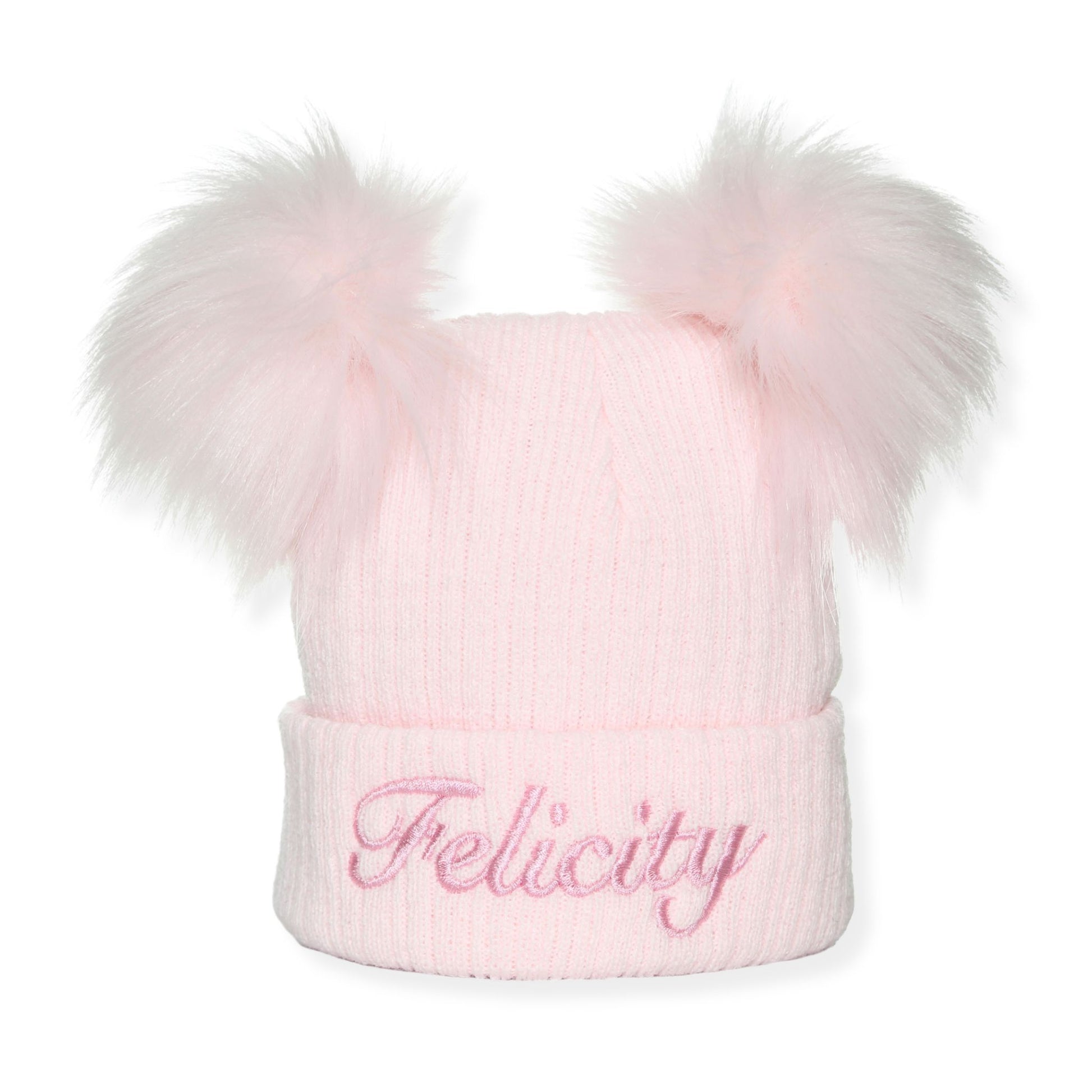 Pink knit beanie with two large fur pom-poms and 'Felicity' embroidery on a white background