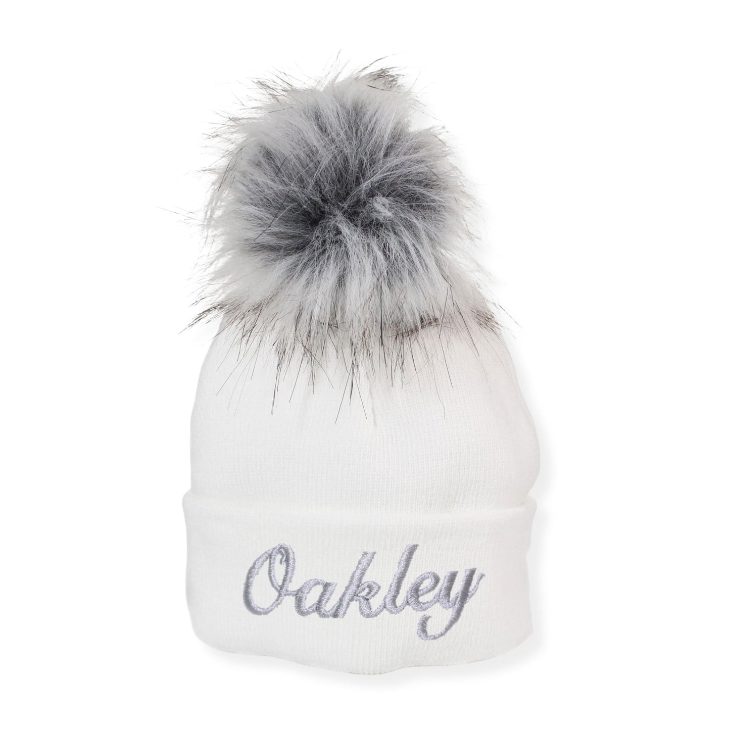 White beanie with gray fur pom-pom and 'Oakley' embroidery on a white background