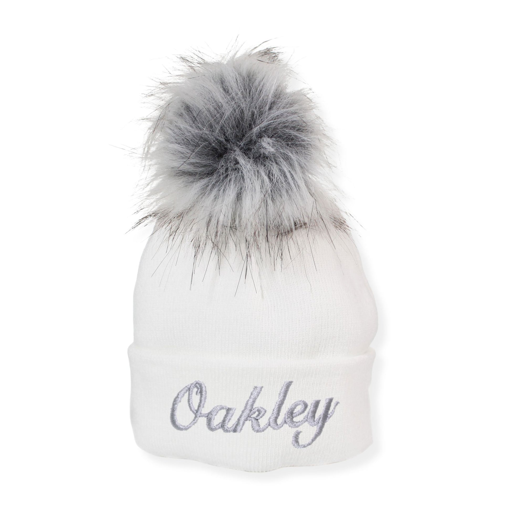 White beanie with gray fur pom-pom and 'Oakley' embroidery on a white background