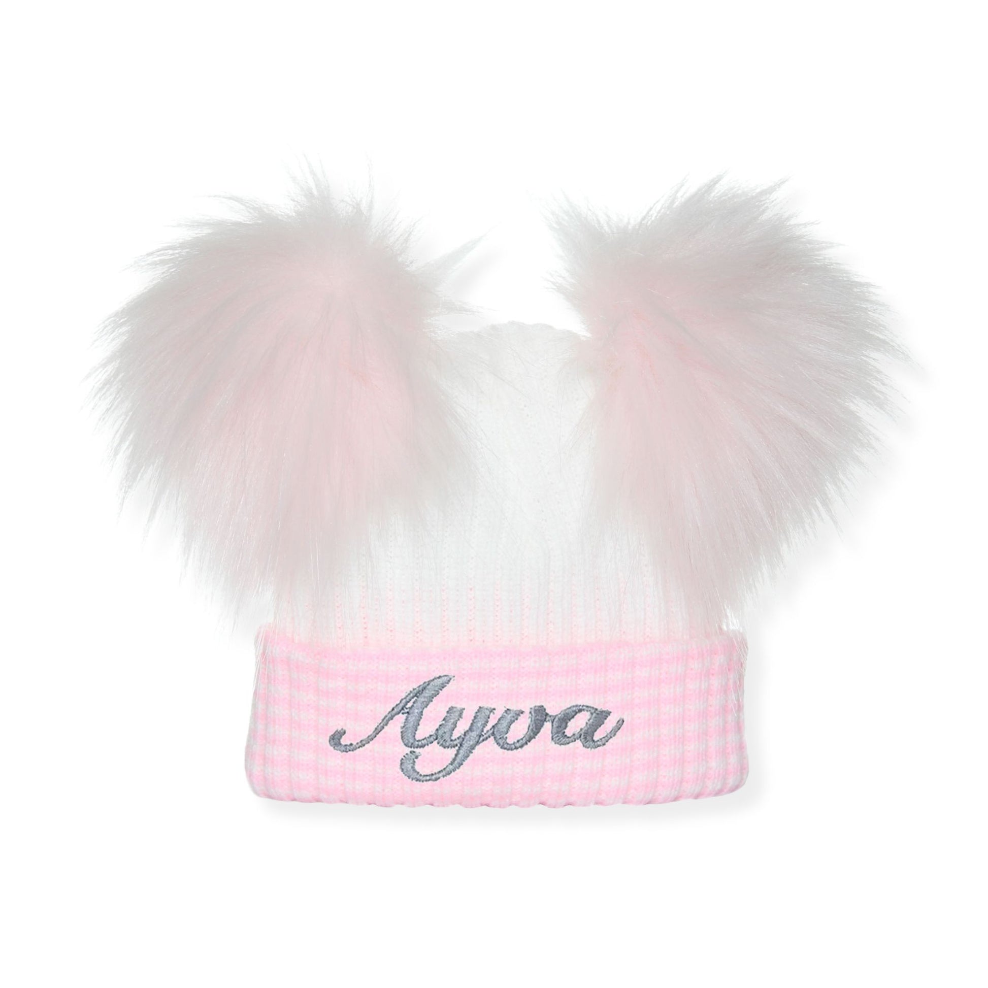 Pink beanie with white fur pom-poms and 'Ayva' embroidery on a white background