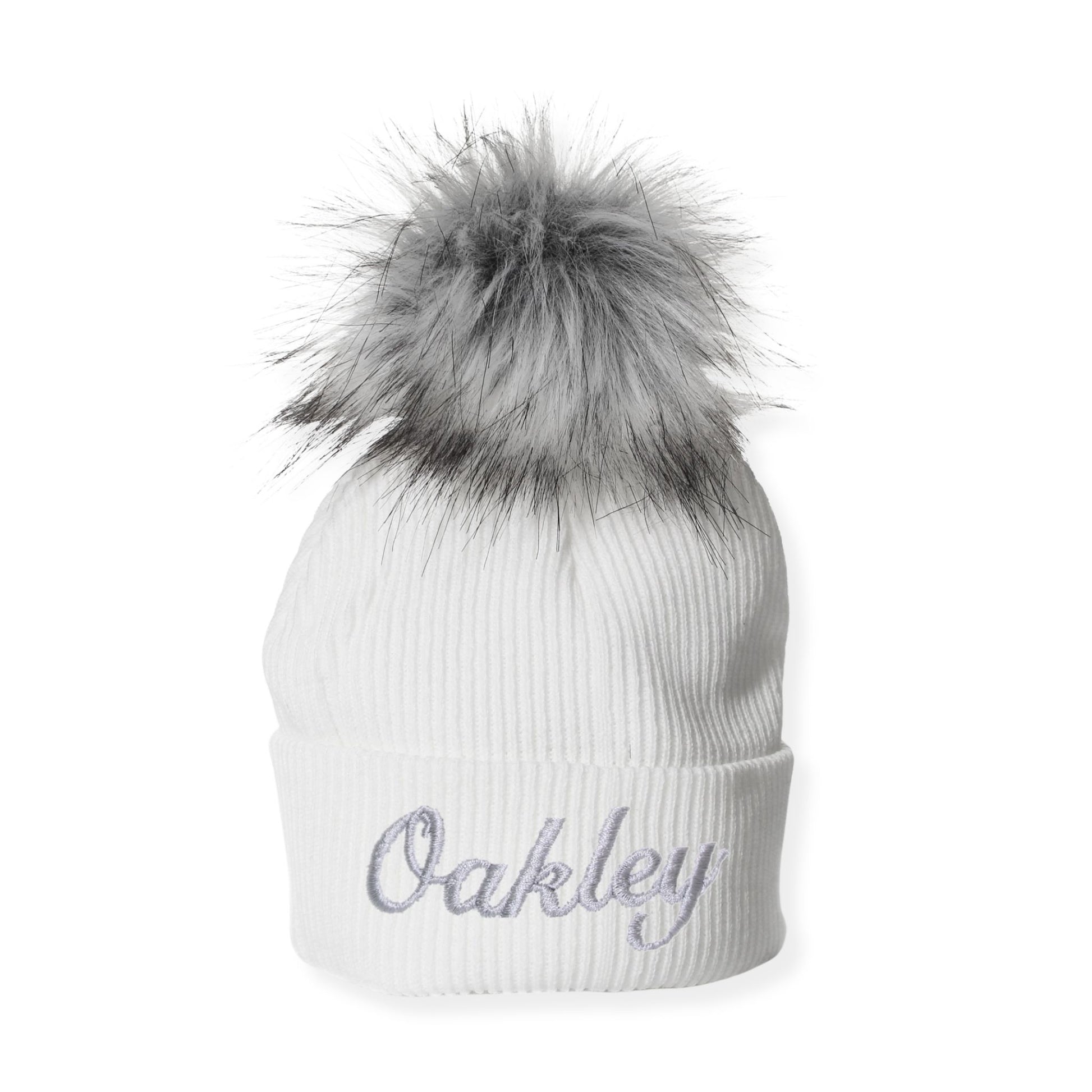 White beanie with gray fur pom-pom and 'Oakley' embroidery on a white background