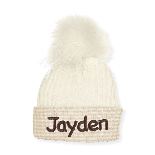 Beige beanie with a white pom-pom and 'Jayden' embroidered on a white background