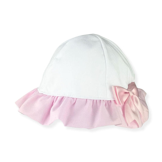 White baby hat with pink ruffle and bow on a white background