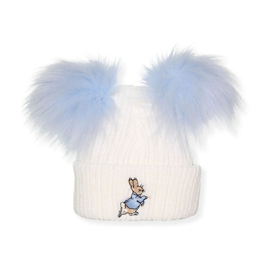 White beanie with blue faux fur pom-poms and a embroidered character on a white background