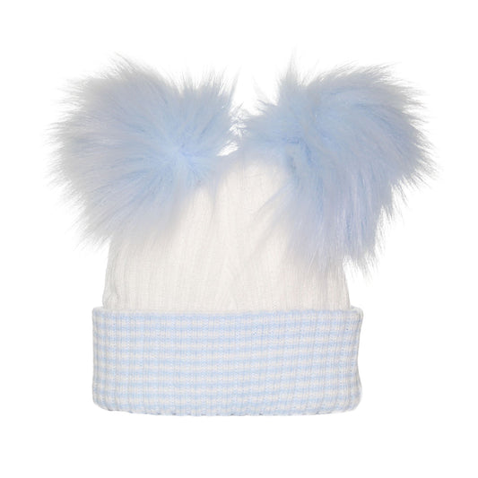 White baby hat with blue checkered trim and large blue faux fur pom-poms on a white background