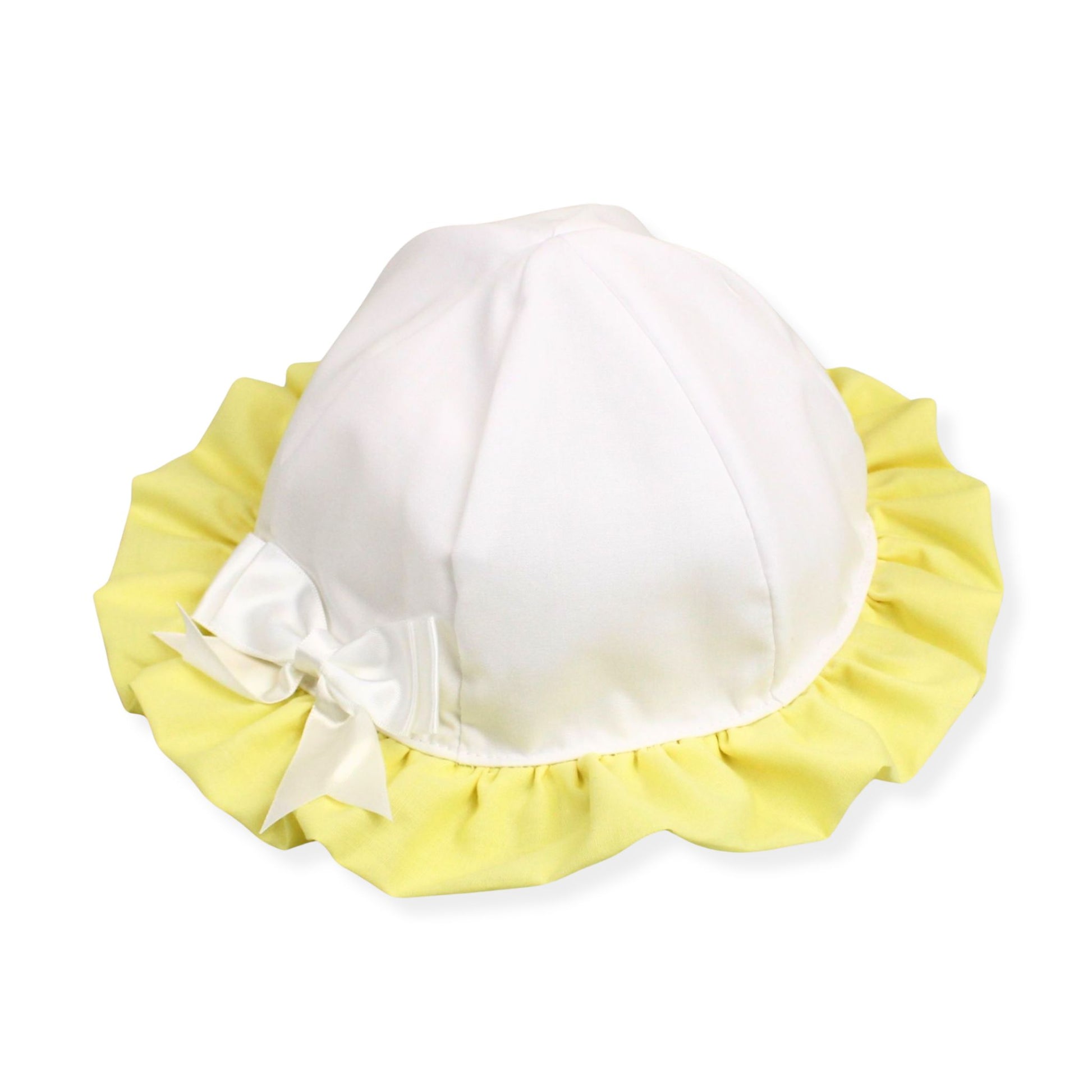 White baby bonnet with yellow trim and a bow on a white background