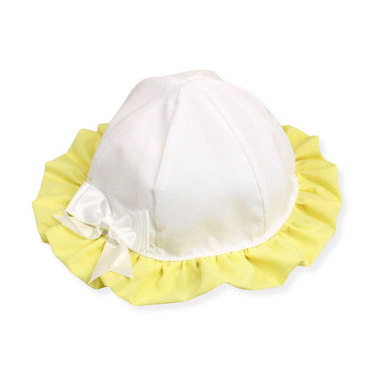 White baby bonnet with yellow trim and a bow on a white background