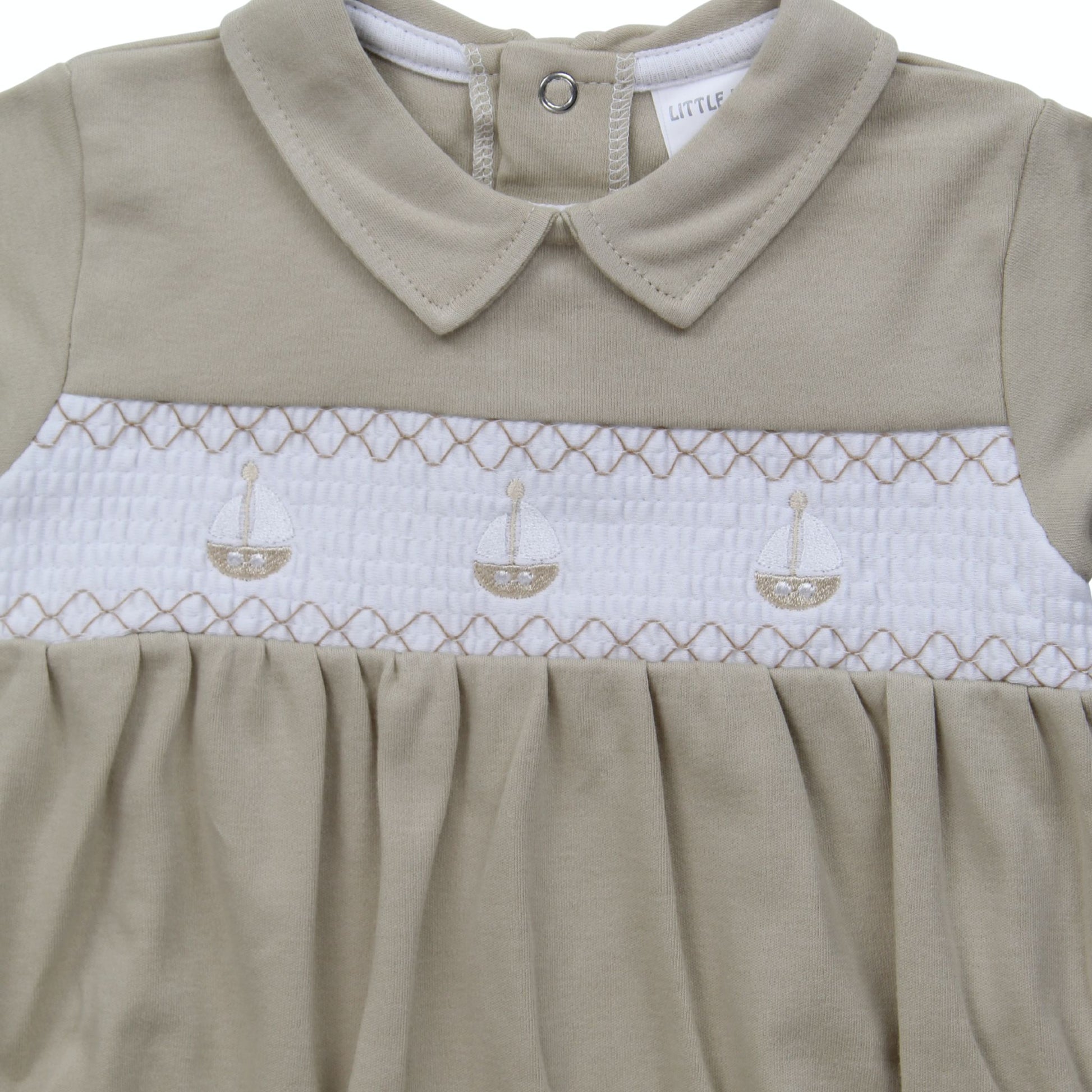Beige baby dress with white smocked bodice and collar, featuring sailboat design.