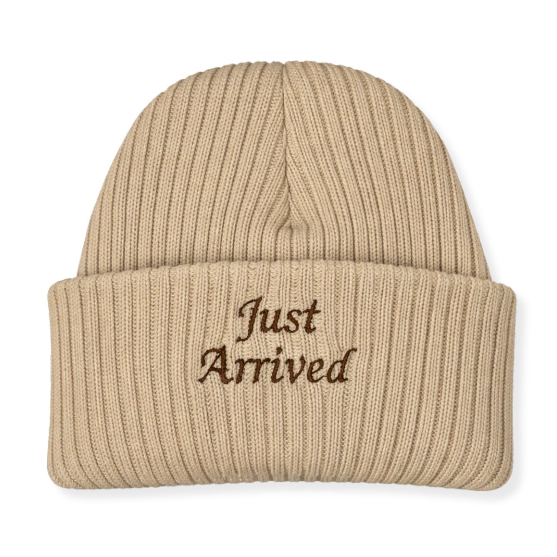 Beige knit beanie with 'Just Arrived' embroidery on a white background