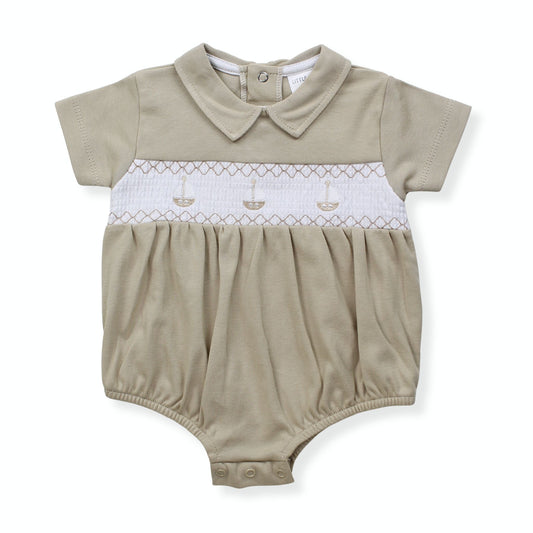 Beige baby romper with white smocked waist on a white background