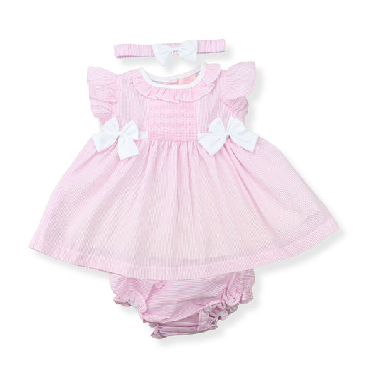 Pink baby dress with white bows and matching bloomers on a white background